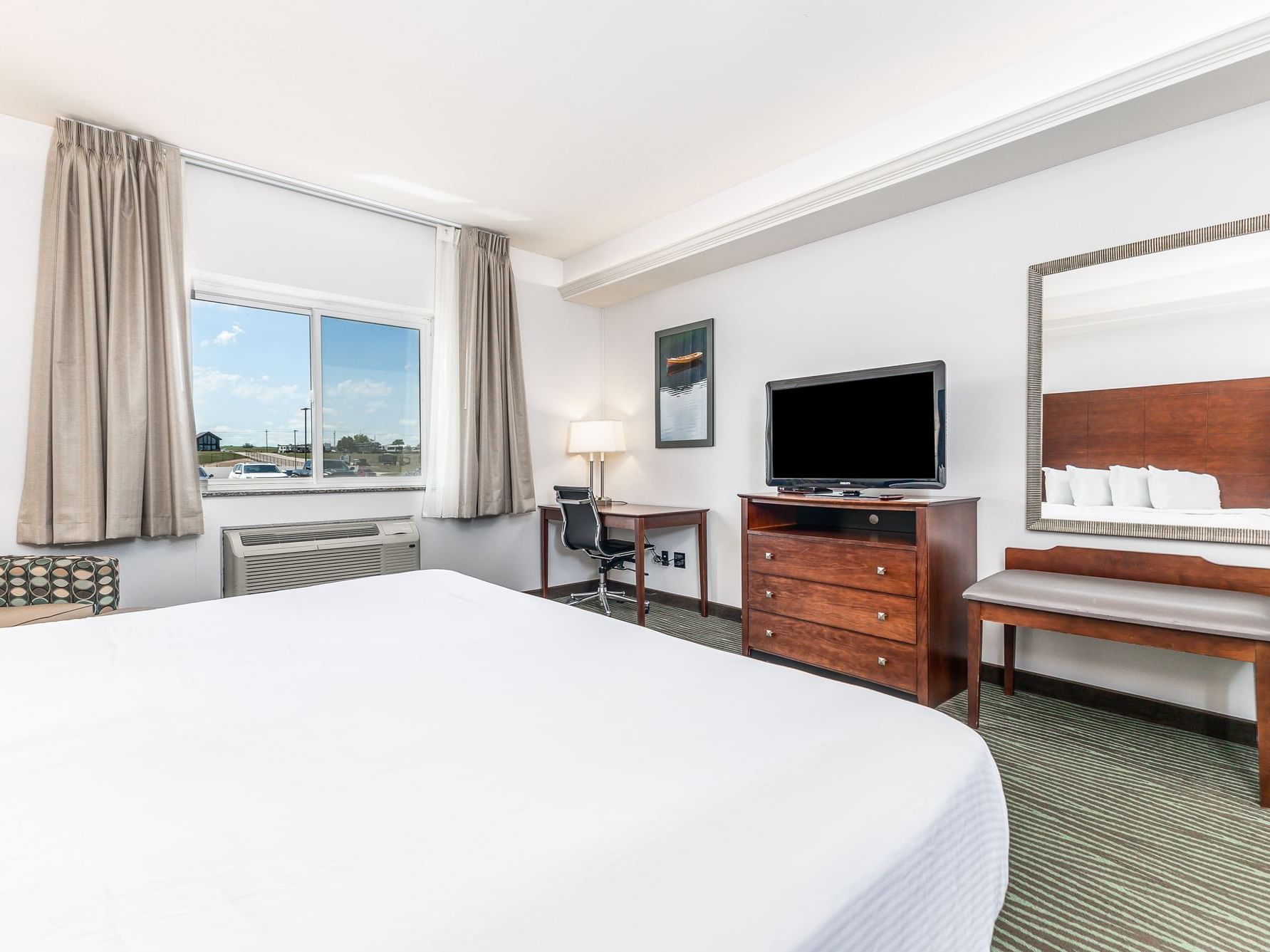 TV and work desk facing the cozy beds in King Resort View Room with carpeted floors at Off Shore Resort
