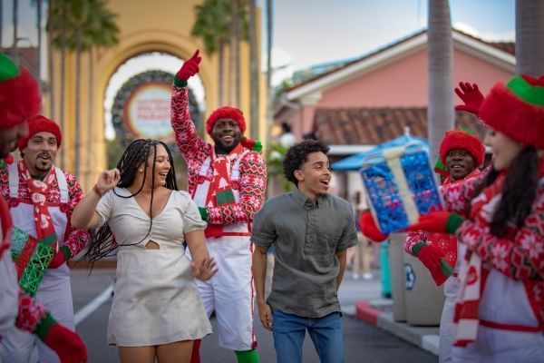 Guests dance in the streets with Universal performers dressed in red during the Macy's holiday parade at Universal.