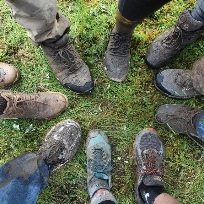 Close-up of a group’s shoes arranged in a circle during their Three Towers hike in Berkshire.