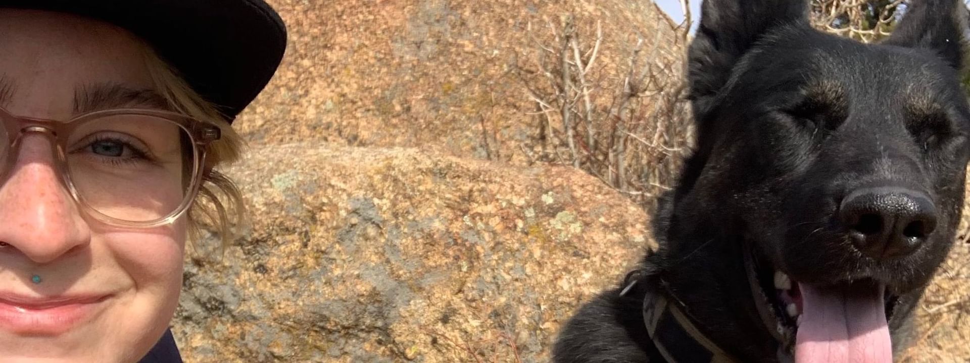 Man & dog posing for a selfie while hiking near Kinship Landing