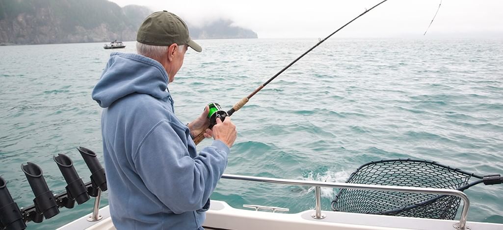 Man salmon fishing from the back of a boat