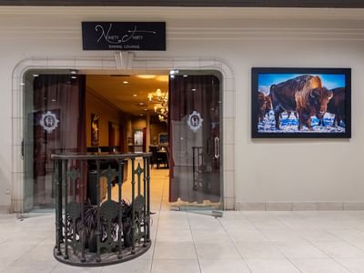 Dining lounge entrance with bison picture on wall at Carriage House Hotel & Conference Centre