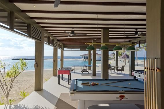 Pool table in Beach Club with dining tables and sea view at Grand Park Kodhipparu, Maldives