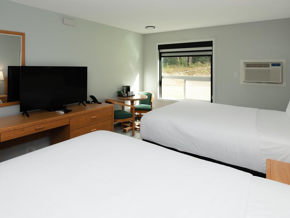Coast Two Queens Pet Friendly room with two queen beds, wooden furniture, and flat-screen TV.