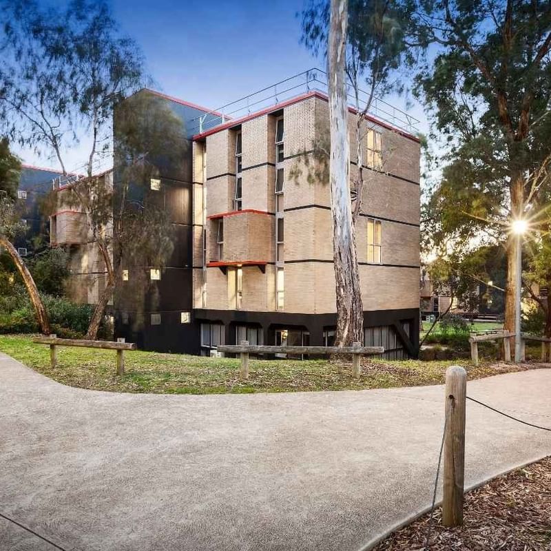 Pathway leading to La Trobe University’s Menzies College surrounded by greenery and trees.