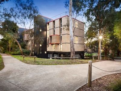 Pathway leading to La Trobe University’s Menzies College surrounded by greenery and trees.