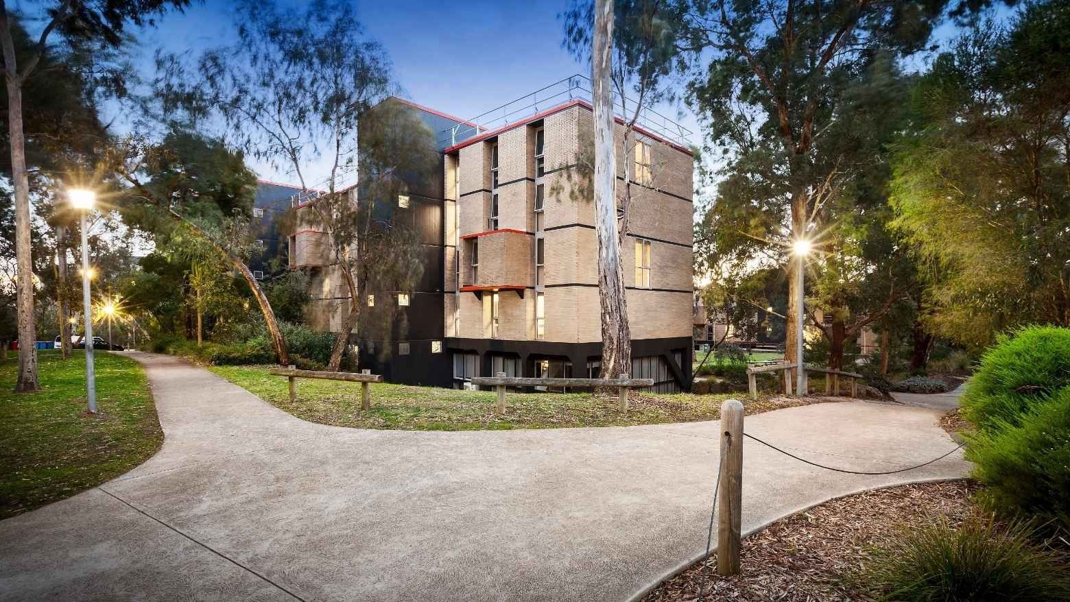 Pathway leading to La Trobe University’s Menzies College surrounded by greenery and trees.