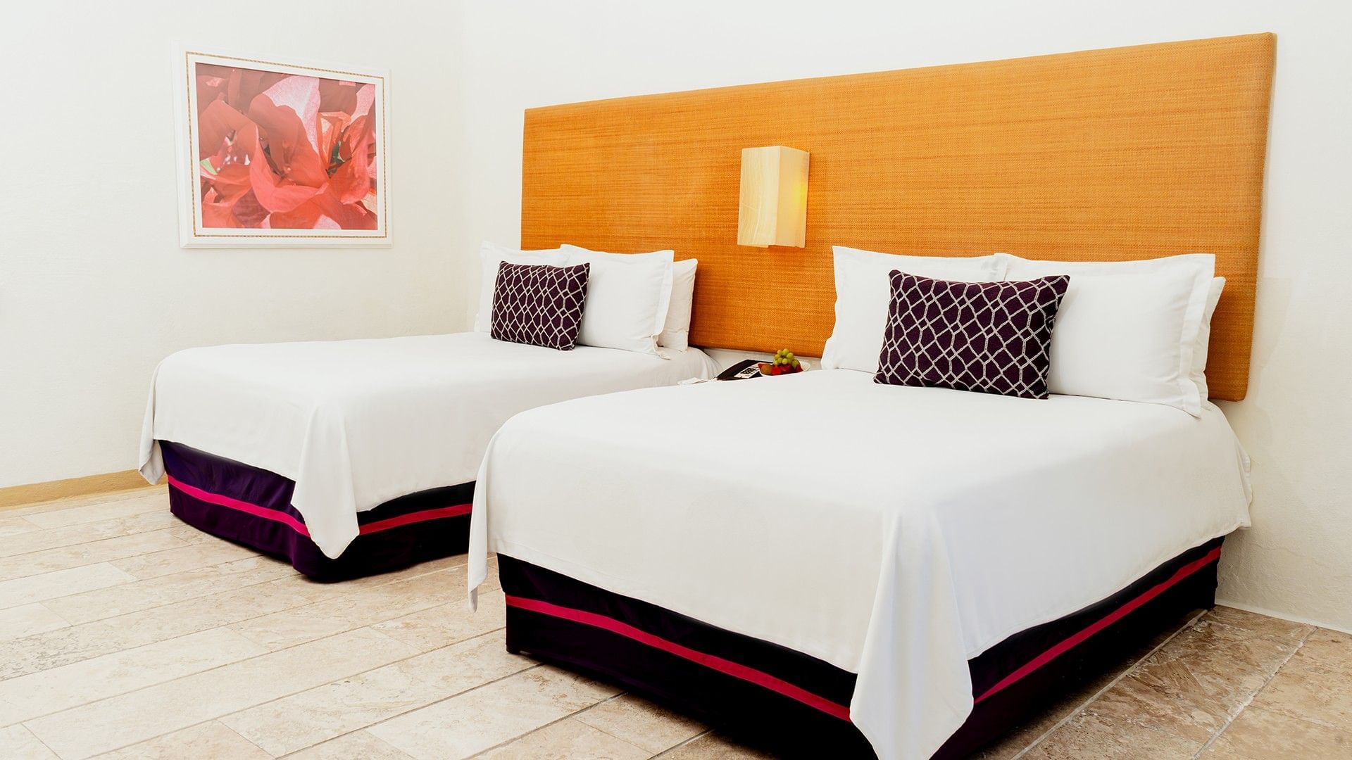 Nightstand by the beds with cushioned headboard and wall art in Two Double Deluxe at Camino Real Zaashila Huatulco