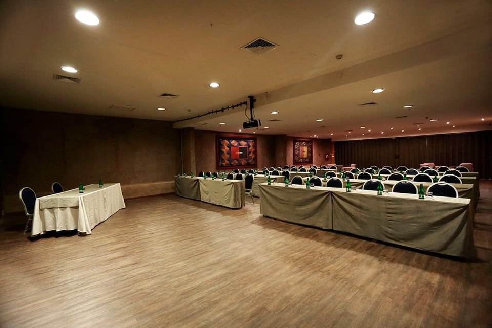 Salón de conferencias con mesas y sillas en Cumbres San Pedro
