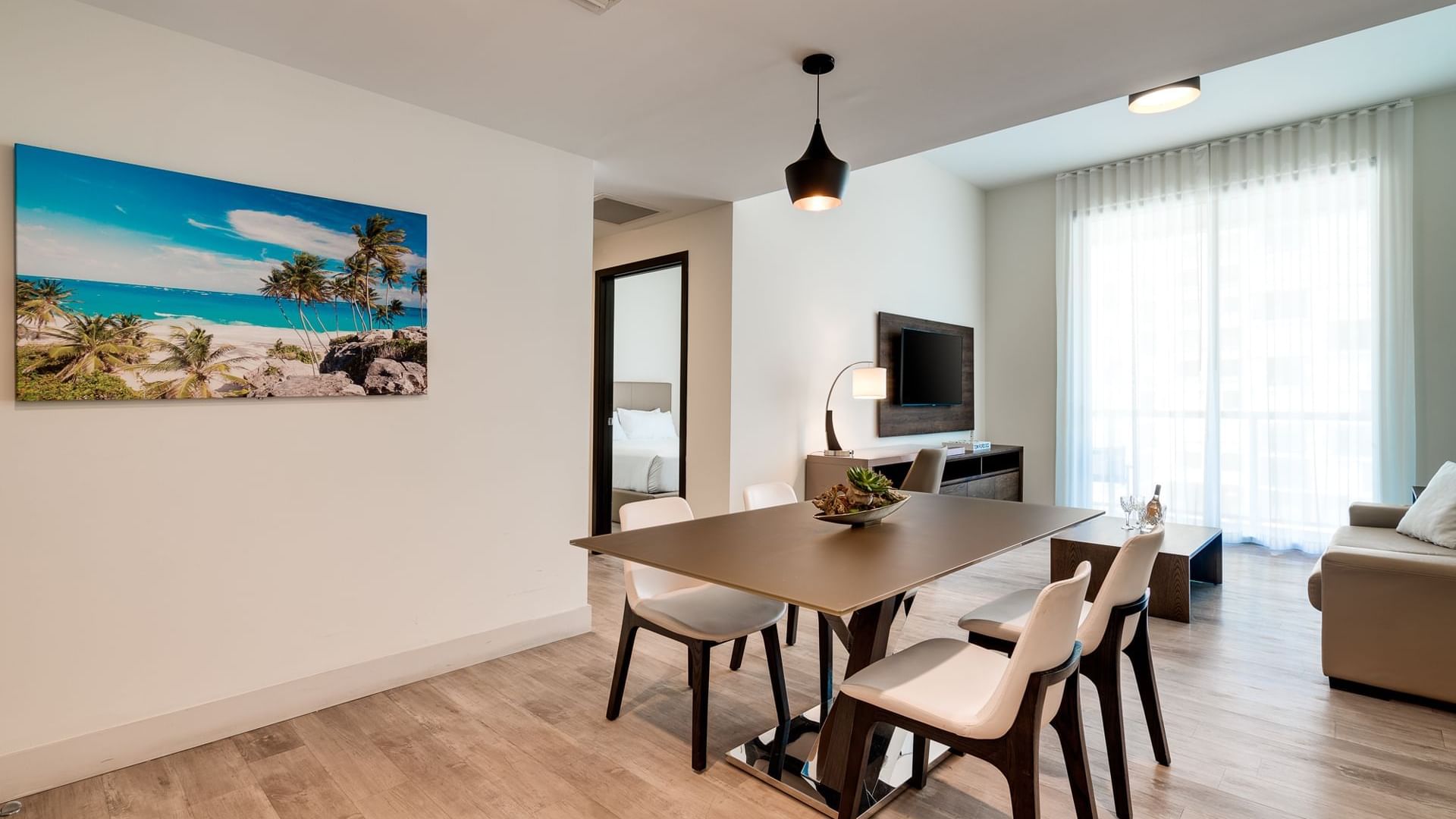 A modern dining area with a table, chairs, and a large piece of beach-themed artwork on the wall.