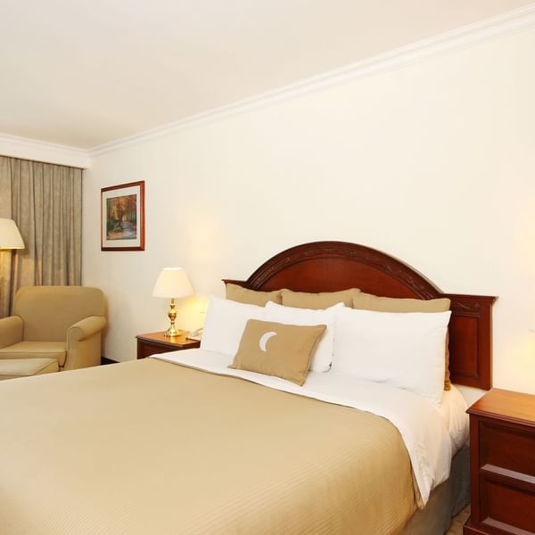 Interior of Deluxe Room with a king bed & lounge at Fiesta Inn
