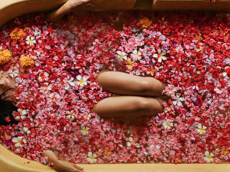 Woman relaxing in a flower bath during the Royal Malaysian Heritage Ritual spa treatment at The Banjaran Hotsprings Retreat