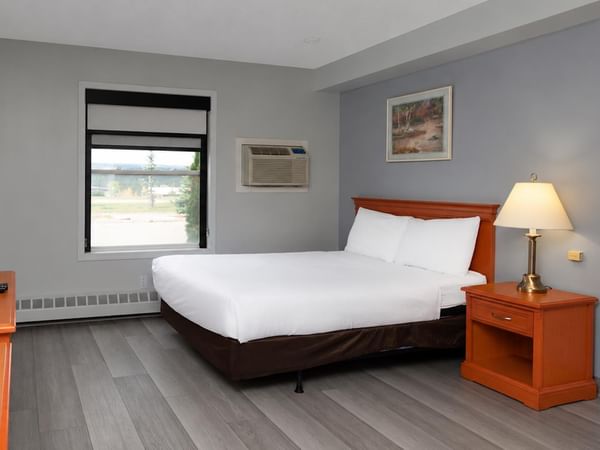 Coast Queen with Kitchenette Pet Friendly room with queen bed, gray wood floors and window.