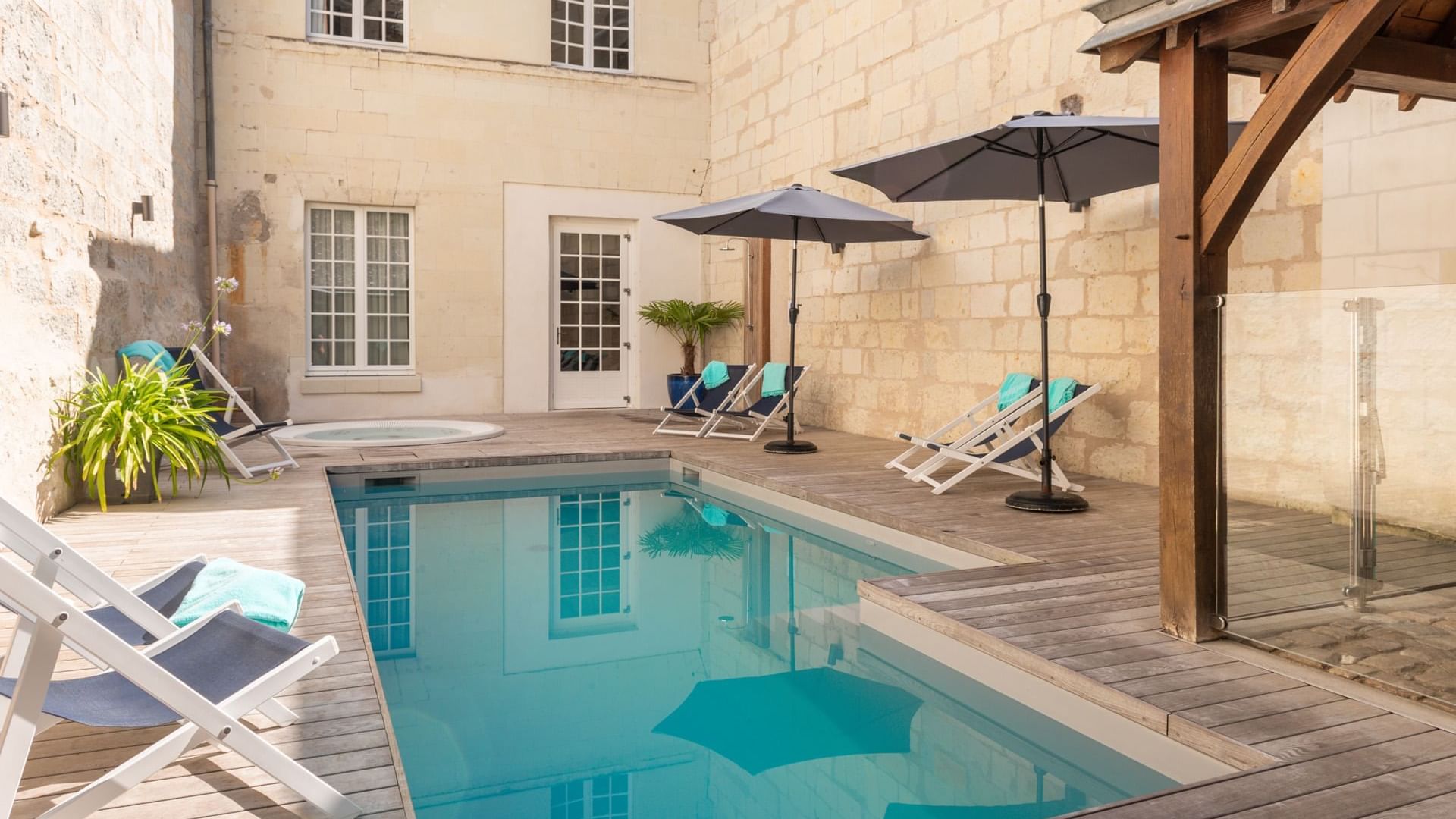 Private outdoor pool with sunbeds on a deck at Originals Hotels