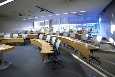 Lecture hall with tiered curved desks, gray chairs, and large windows at the Schulich School of Business.