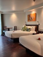 Two Garden View Two Double Rooms with wooden floors and white linens at Warwick Fiji in Korolevu.