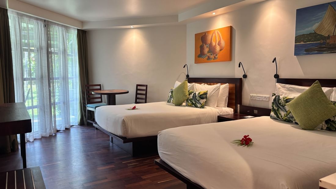 Two Garden View Two Double Rooms with wooden floors and white linens at Warwick Fiji in Korolevu.