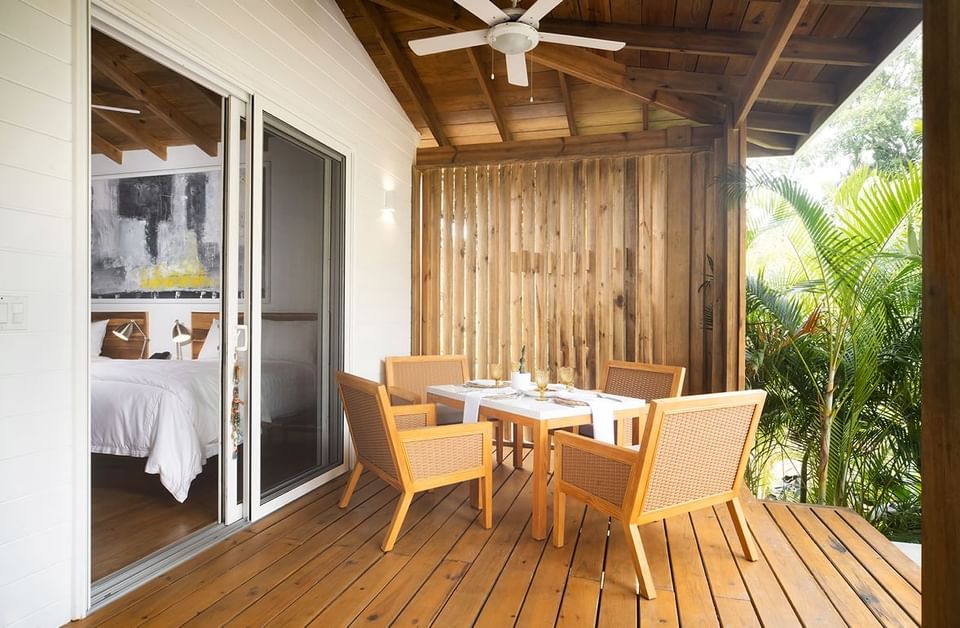 Relaxing terrace on the Ibagari Hotel, featuring a table with four chairs and lush tropical foliage