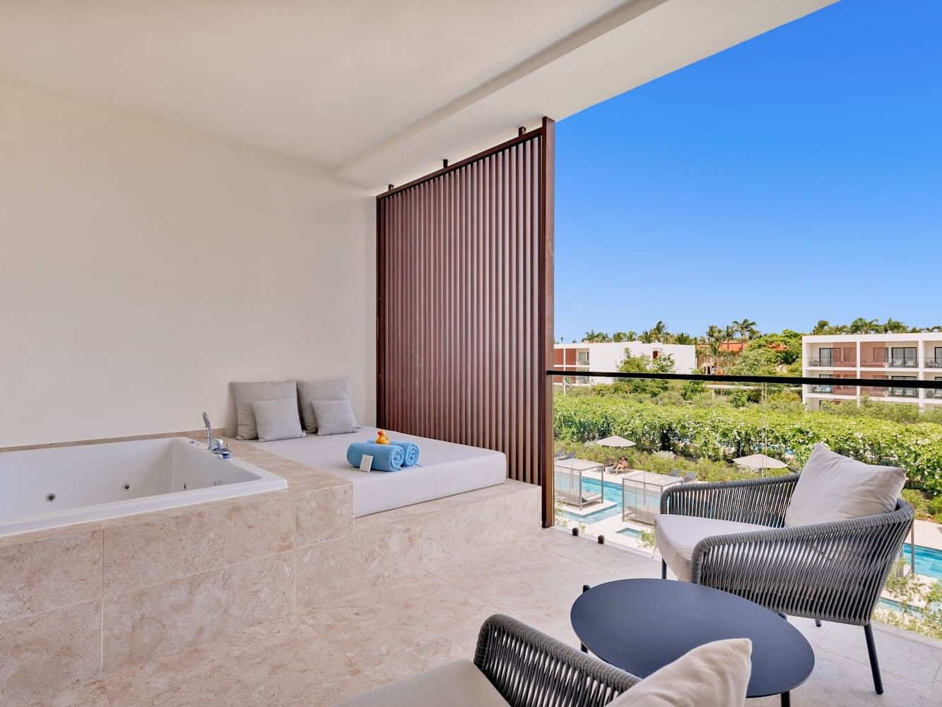 Bathtub by the spa bed and seating area in Premium Pool View room at Live Aqua Punta Cana