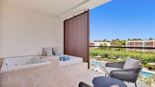 Bathtub by the spa bed and seating area in Premium Pool View room at Live Aqua Punta Cana