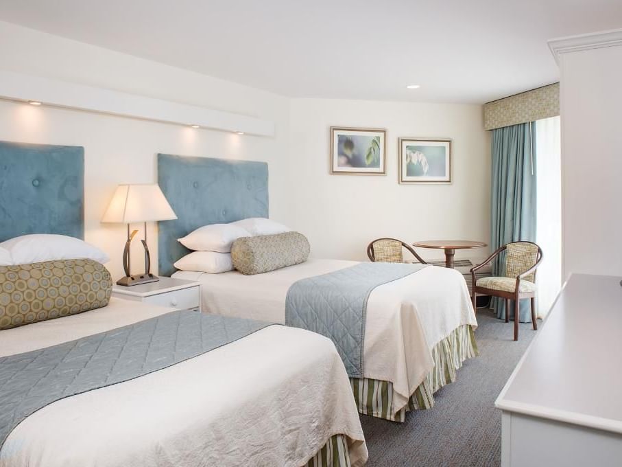 Twin beds with nightstand and sitting area in Towers Front at Anchorage By The Sea