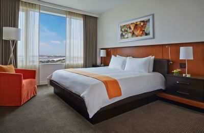a comfy bed and chair in a hotel room