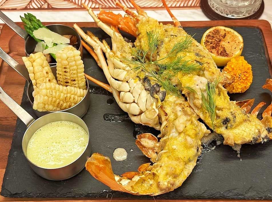 Close-up of a lobster dish served with a side of corn & dip at Imperial Lexis best Malaysian Restaurants Kuala Lumpur