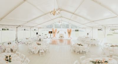 Banquet seating with white linens and pink floral accents in Spencer Meadows Pavilion at Spencer Hotel & Conference Centre