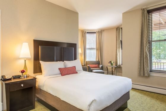 Bed with a lamp in Queen Turret Suite at The Centennial Hotel