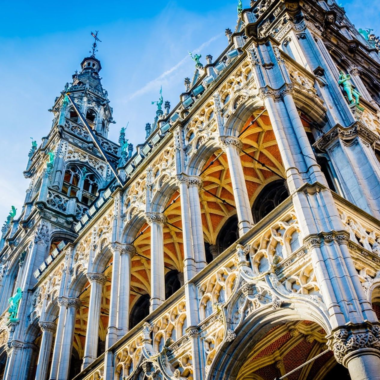 Elaborate Gothic architecture with spires and statues under a blue sky near Hotel Barsey by Warwick