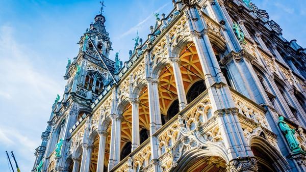 Elaborate Gothic architecture with spires and statues under a blue sky near Hotel Barsey by Warwick