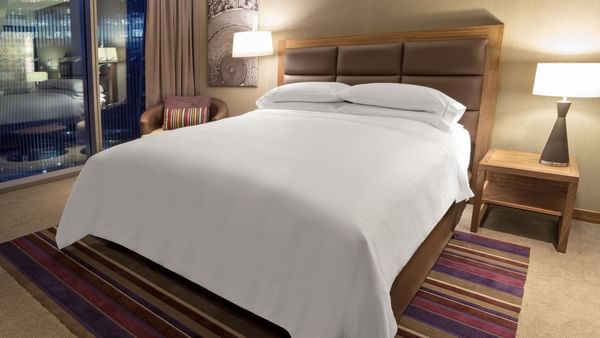 Two bedside lamps with carpeted floor in Deluxe Room, 1 King at Fiesta Americana