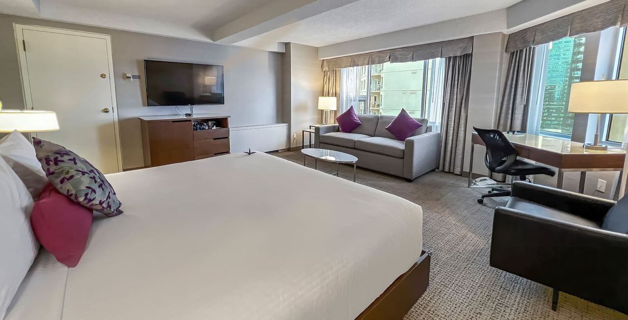 Hotel room with king bed, a sofa bed, TV, work desk, and a view