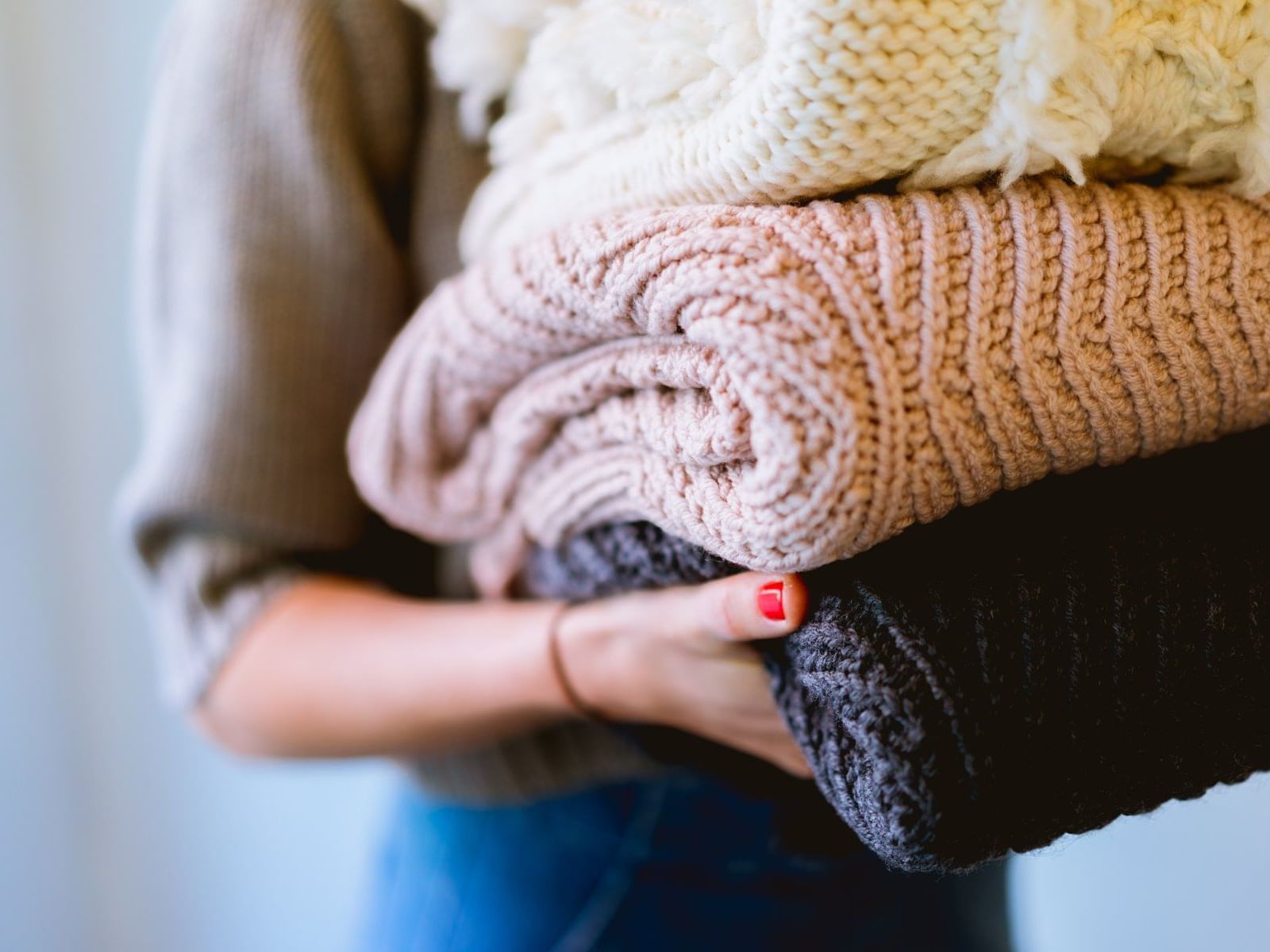 An employee carrying three fresh blankets at New Haven Hotel