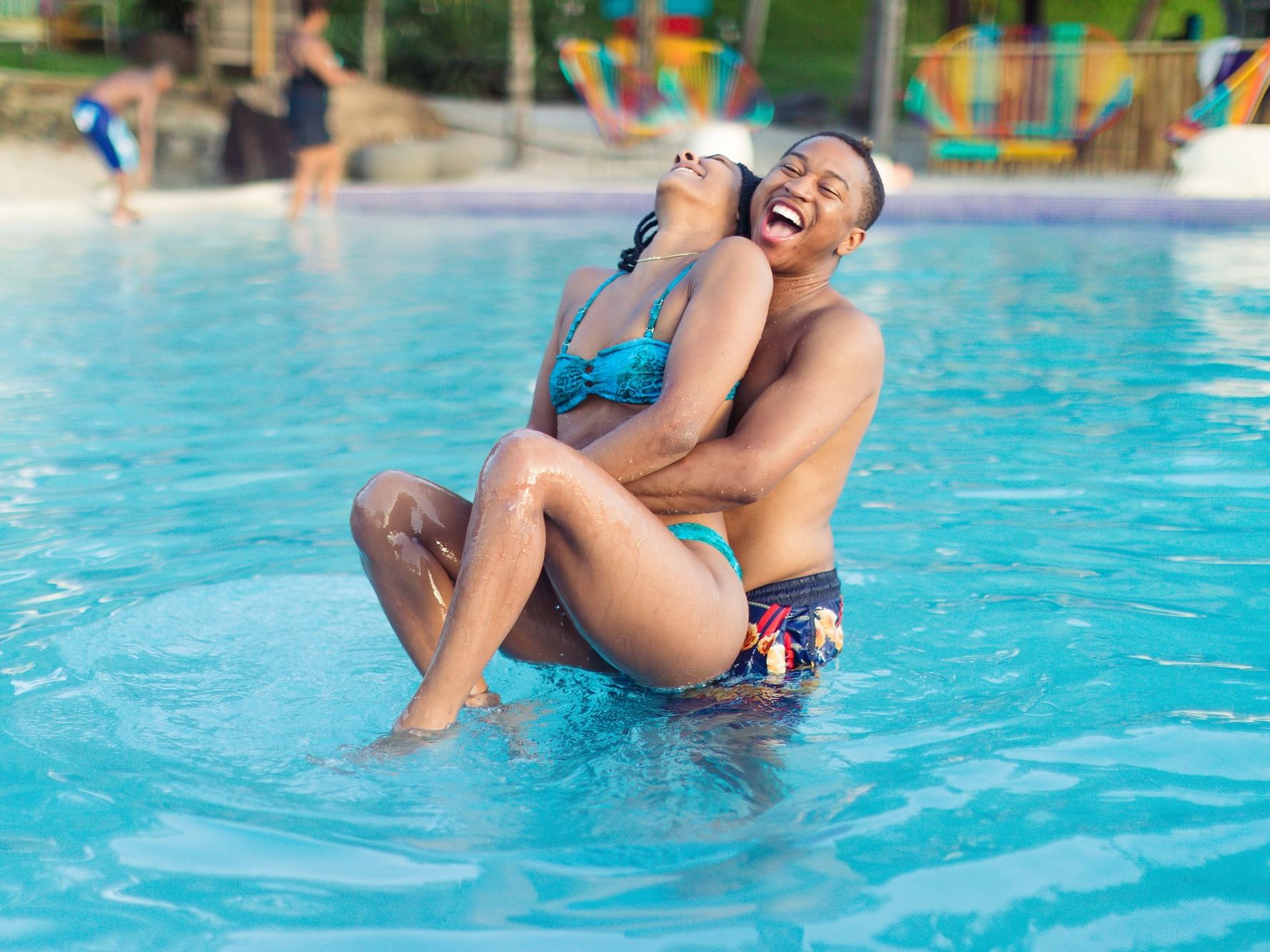 A couple having fun in the outdoor pool at True Blue Bay Resort