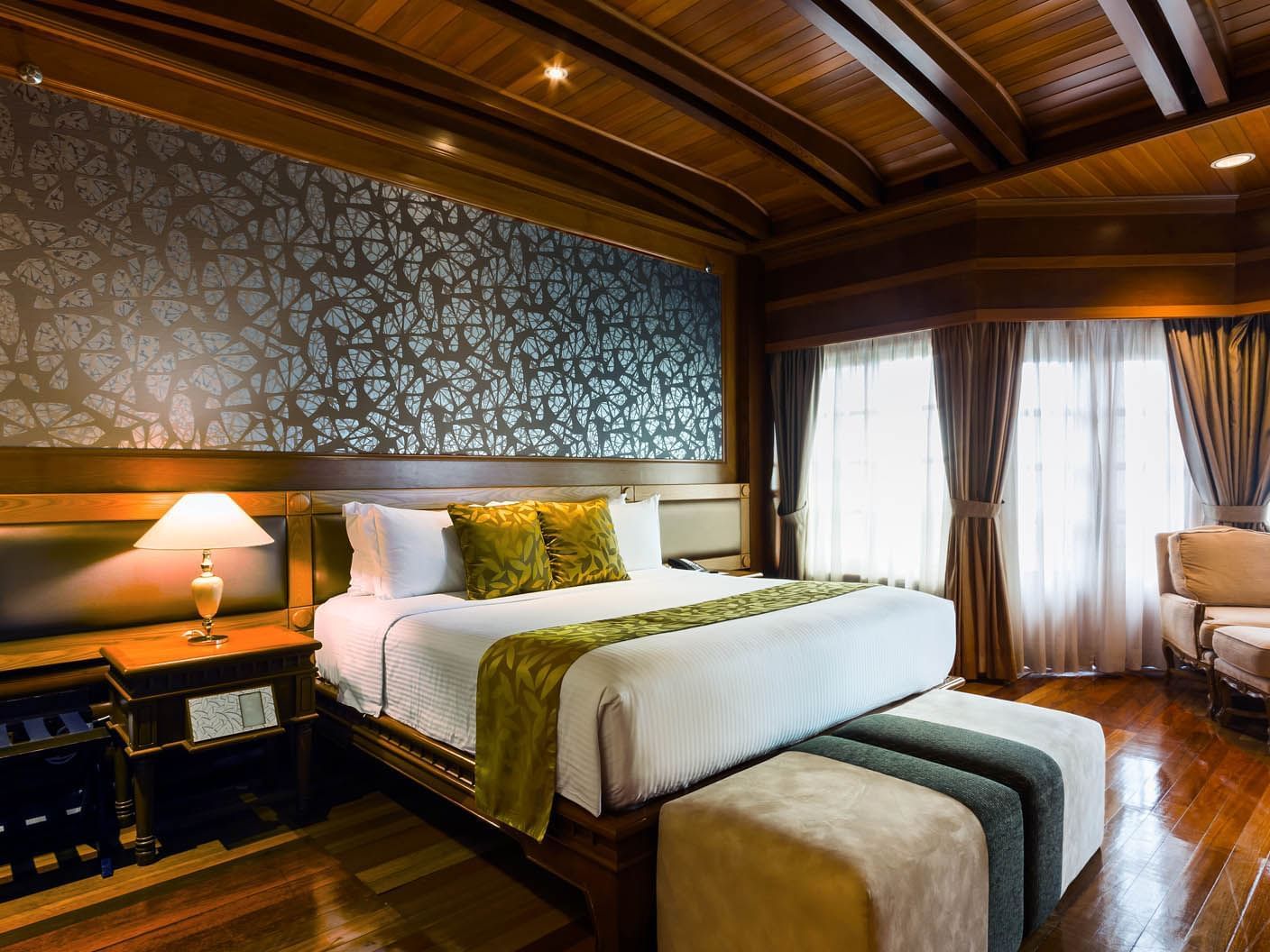 The Presidential Suite with one king bed, a chair and side table at the Thistle Port Dickson Resort