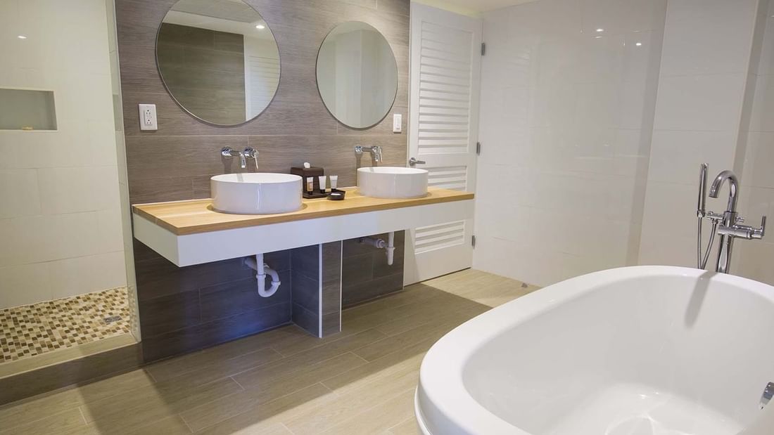 Bathroom vanity & a bathtub in One Bedroom Harbourfront Suite at Warwick Paradise Island Bahamas