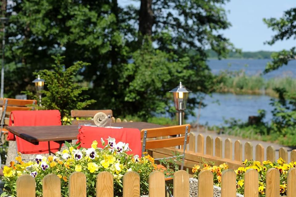 Outdoor dining area with a lake view at Müggelseeperle Hotel