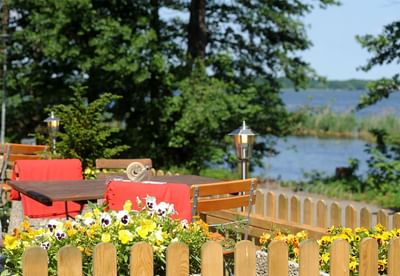 Outdoor dining area with a lake view at Müggelseeperle Hotel