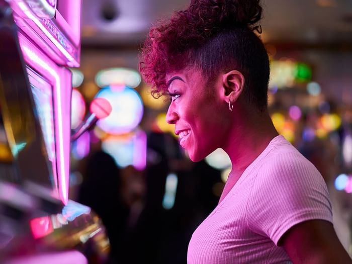 Woman playing slot machine at a casino