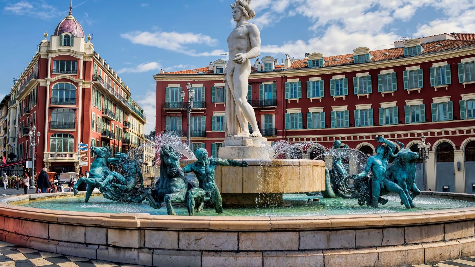 A scenic view of Nice square place, showcasing a prominent fountain surrounded by buildings near Warwick Hotels and Resorts