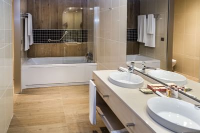 bathroom with double sink and bathtub