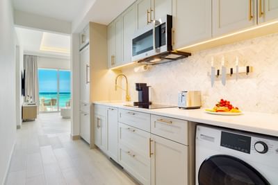 Kitchen with modern appliances and a fruit platter in Three Bedroom Beachfront Junior Suite at Windsong Resort On The Reef