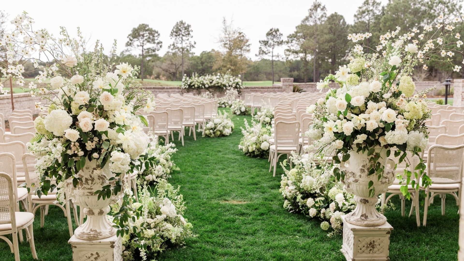 Chairs and floral arrangements on green lawn for a wedding at Camp Creek Inn Inlet Beach.