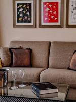 Coin salon avec canapé, verres à vin et œuvres d'art dans la chambre « Penthouse Executive Terrace » du Warwick Geneva à Genève.
