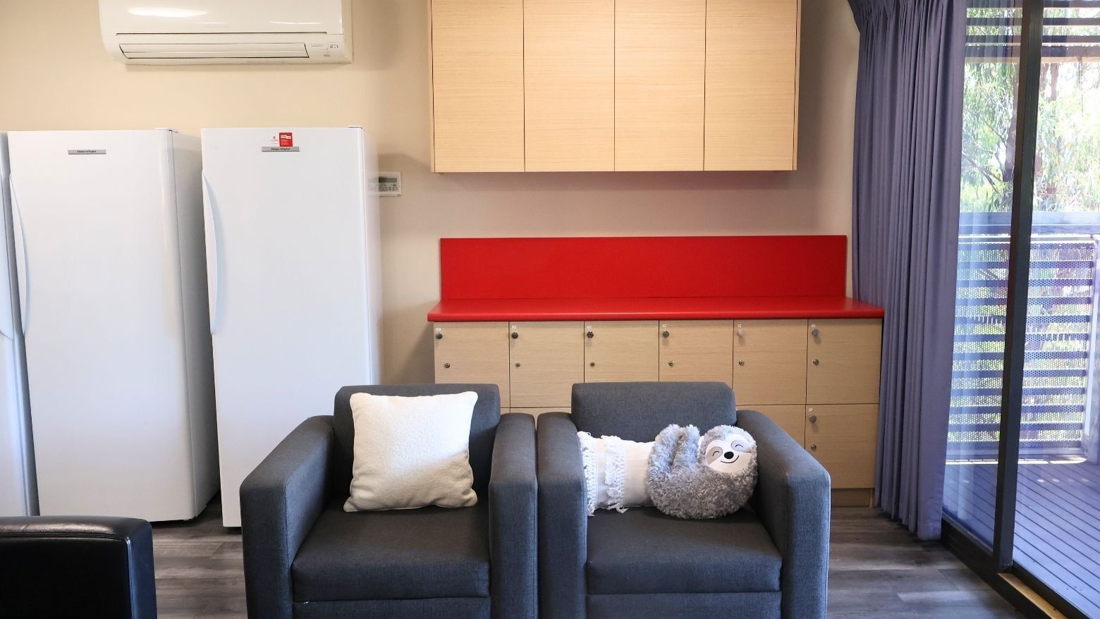 Two comfortable chairs with pillows and stuffed toy in a modern Hillside Apartments living space.