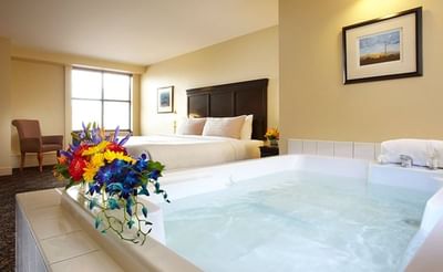 Jetted tub by the king bed in Luxury Mineral Spa Suite at Temple Gardens Hotel & Spa
