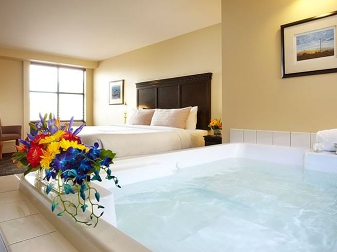 Jetted tub by the king bed in Luxury Mineral Spa Suite at Temple Gardens Hotel & Spa