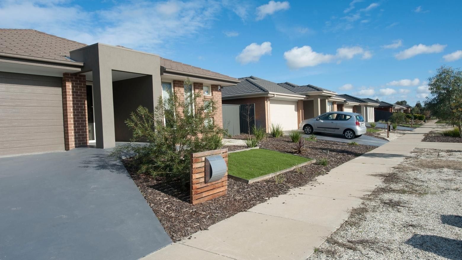 Modern houses with car parked and well-maintained garden at La Trobe University Regional Housing Shepparton.