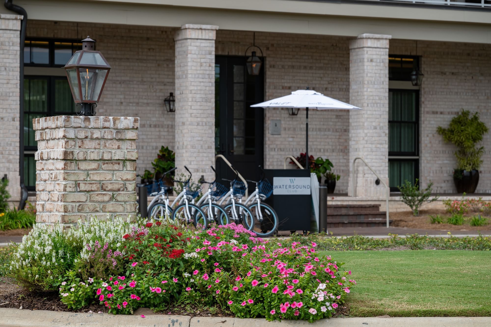 Bicycles, umbrella, and outdoor lamps on the front lawn of Camp Creek Inn